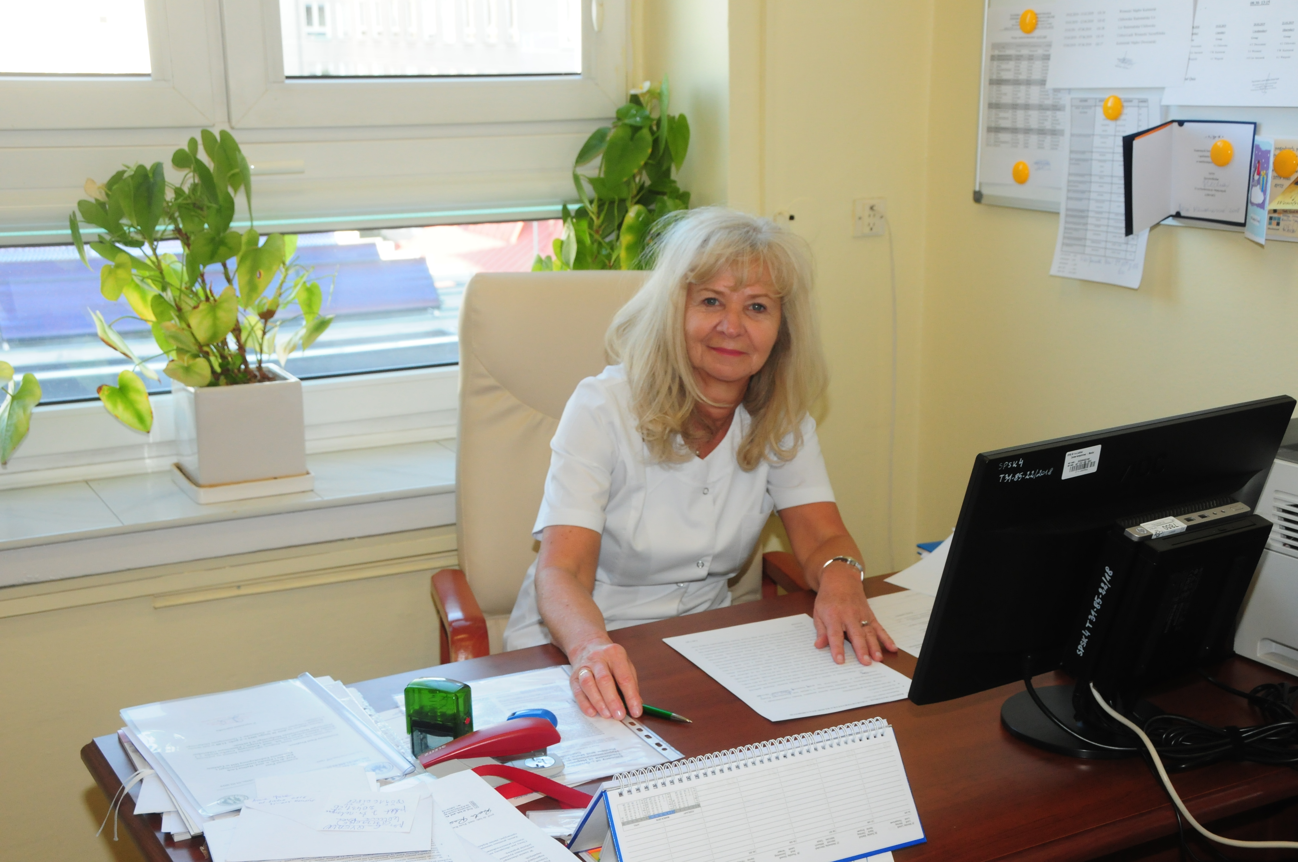 prof. Halina Lach siedzi przy biurku w gabinecie
