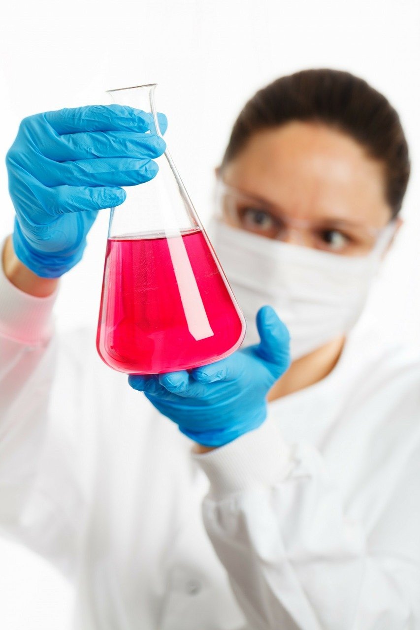kobieta z w laboratorium z różowym płynem w szklanym nacz