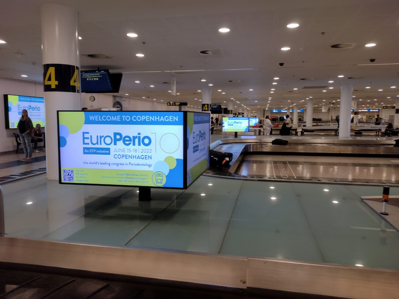 Hala lotniska w miejscu odbioru bagażu, na banerze multimedialnym znajduje się logo EuroPerio10