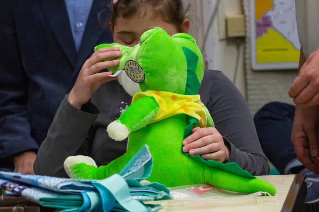 dziecko dotyka pluszowego dinozaura