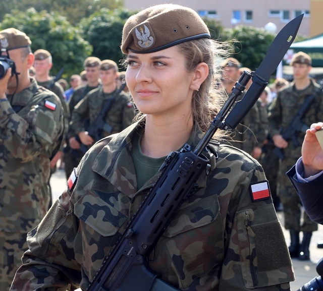 młoda kobieta w mundurze z bronią na ramieniu