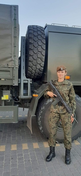 kobieta w mundurze na tle wojskowej ciężarówki
