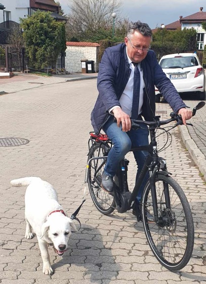 Prof. Borowicz jedzie na rowerze, obok biegnie jego pies, labrador Bonnie