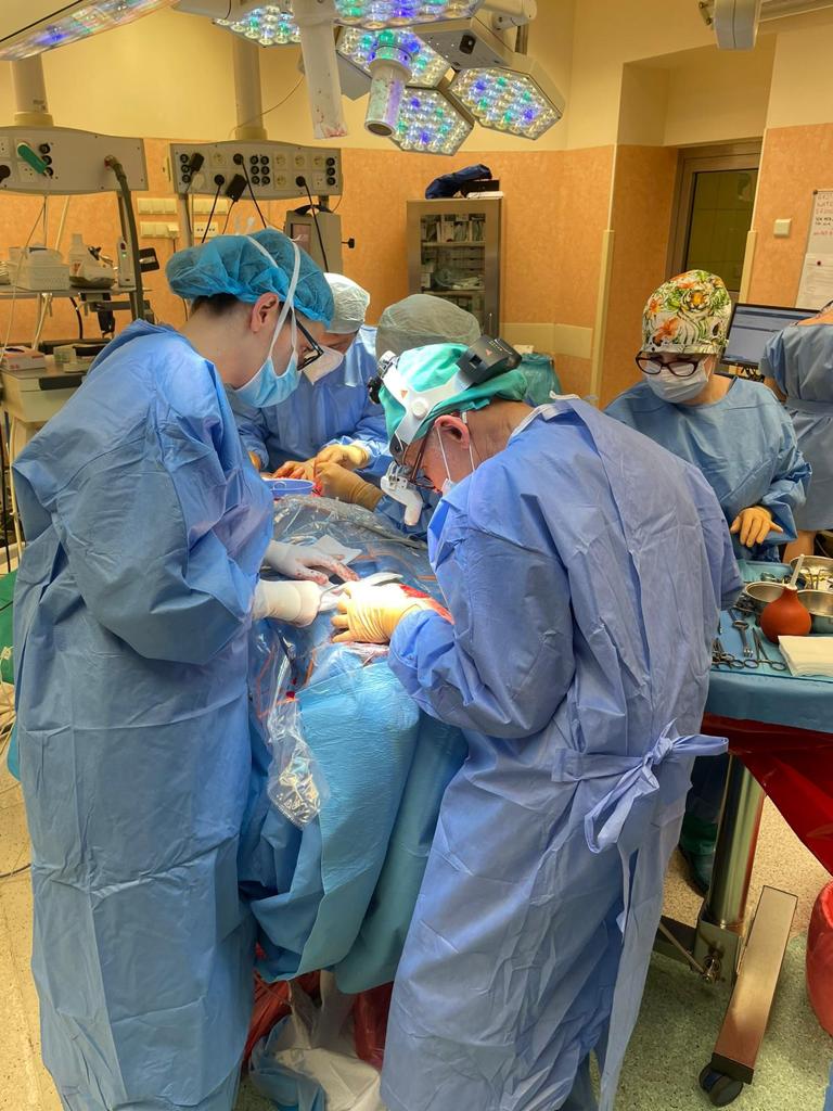 Zdjęcie z sali operacyjnej, lekarze w trakcie operacji wokół stołu operacyjnego