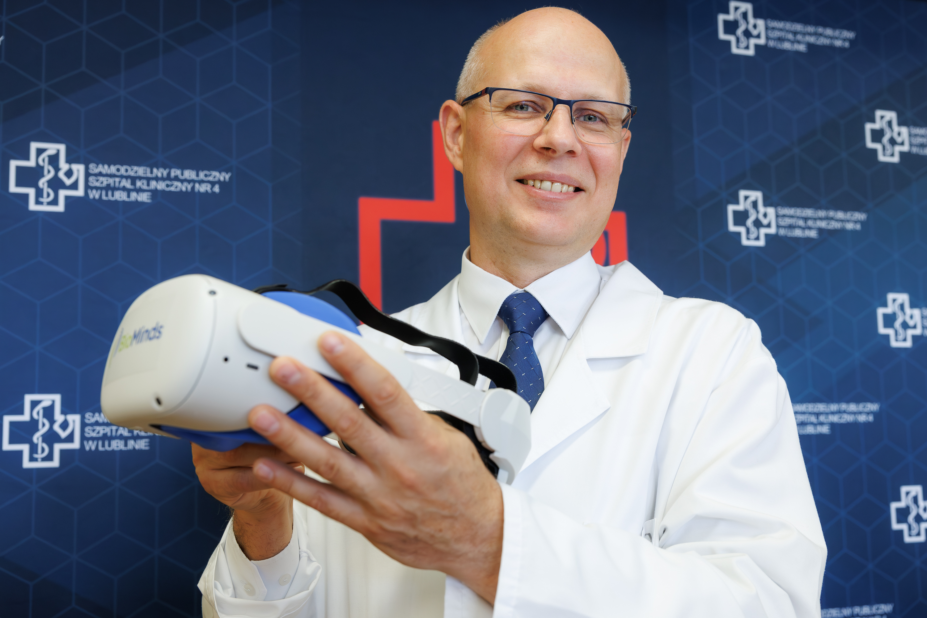 profesor Tomasz Blicharski trzyma okulary VR używane przy rehabilitacji