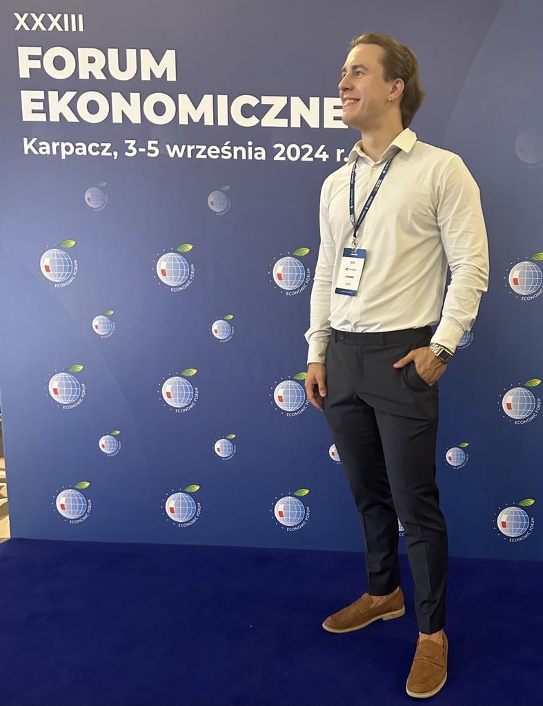 Kacper Curzytek pozuje przy ściance eventowej na XXXIII Forum Ekonomicznym w Karpaczu