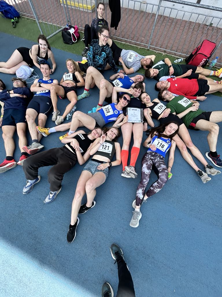 sportowcy z sekcji lekkiej atletyki leżą na boisku