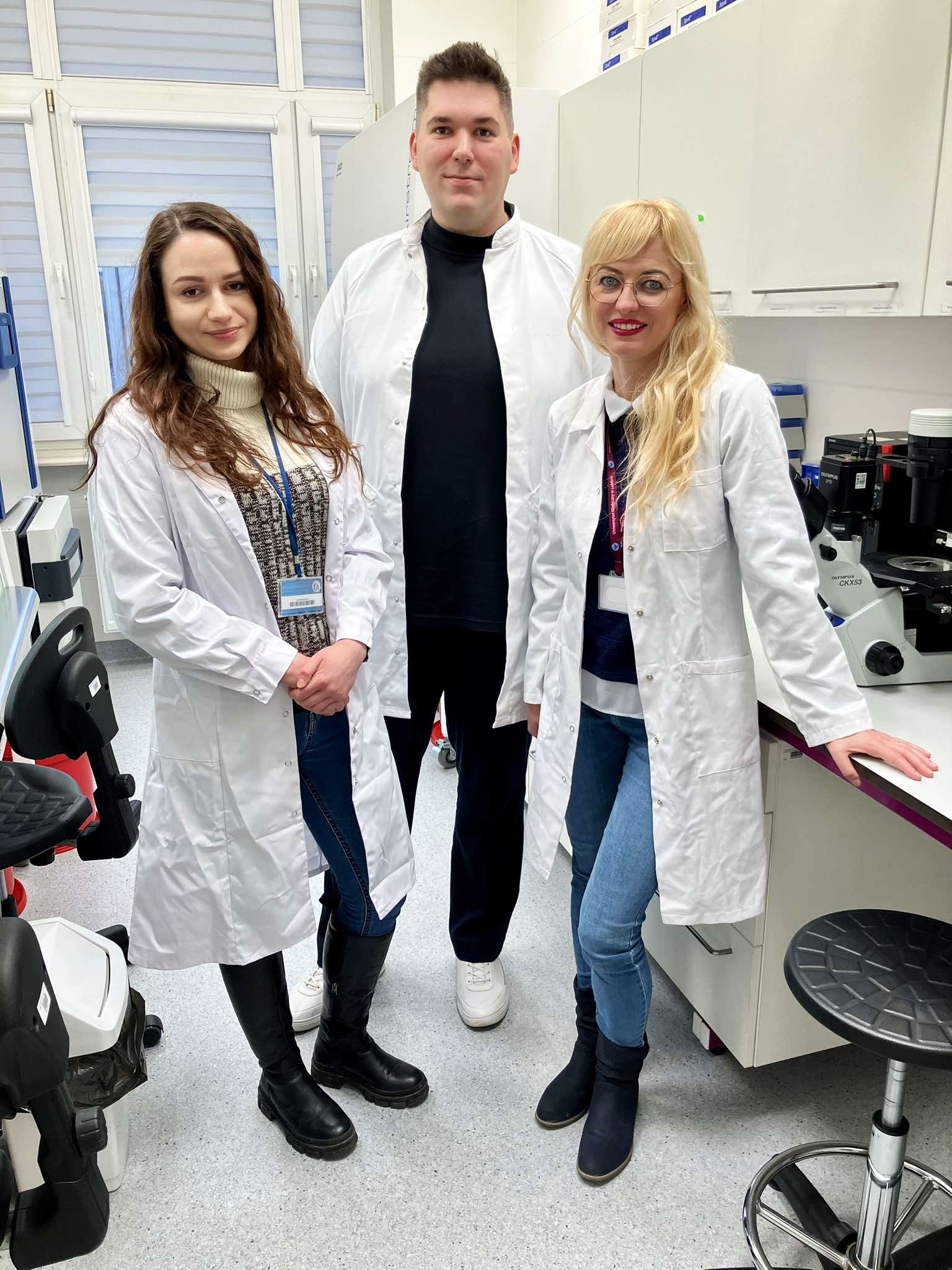 trzy osoby w białych kitlach w laboratorium