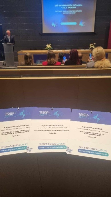 sala konferencyjna w tle, na pierwszym planie identyfikatory uczestników