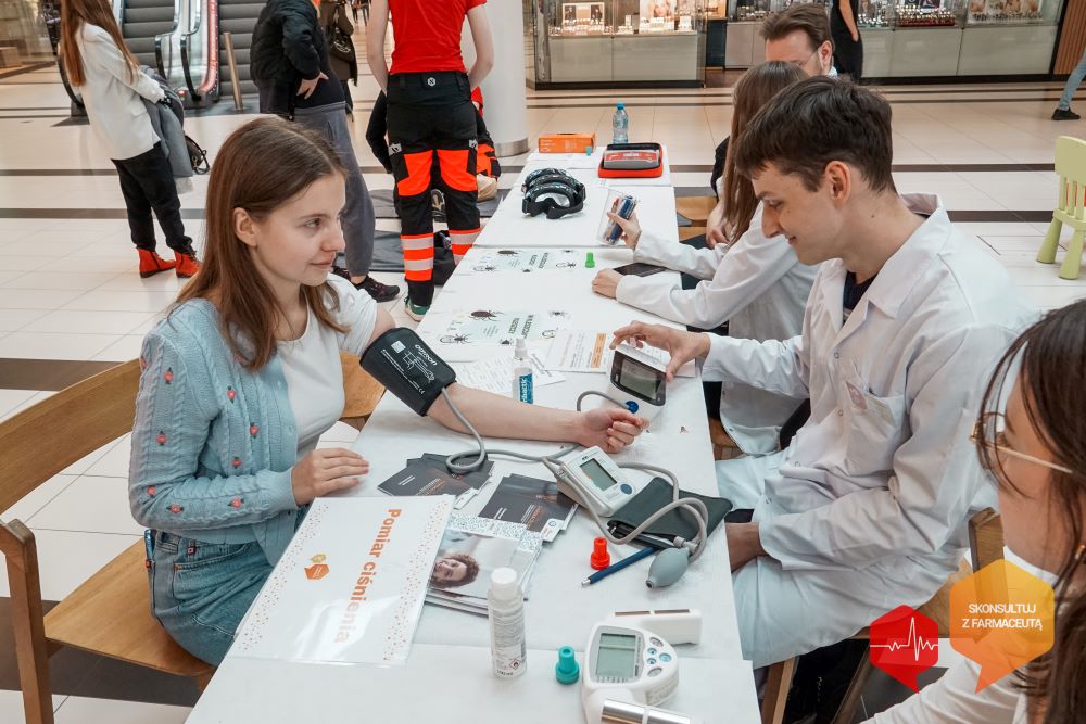 mężczyzna mierzy ciśnienie kobiecie