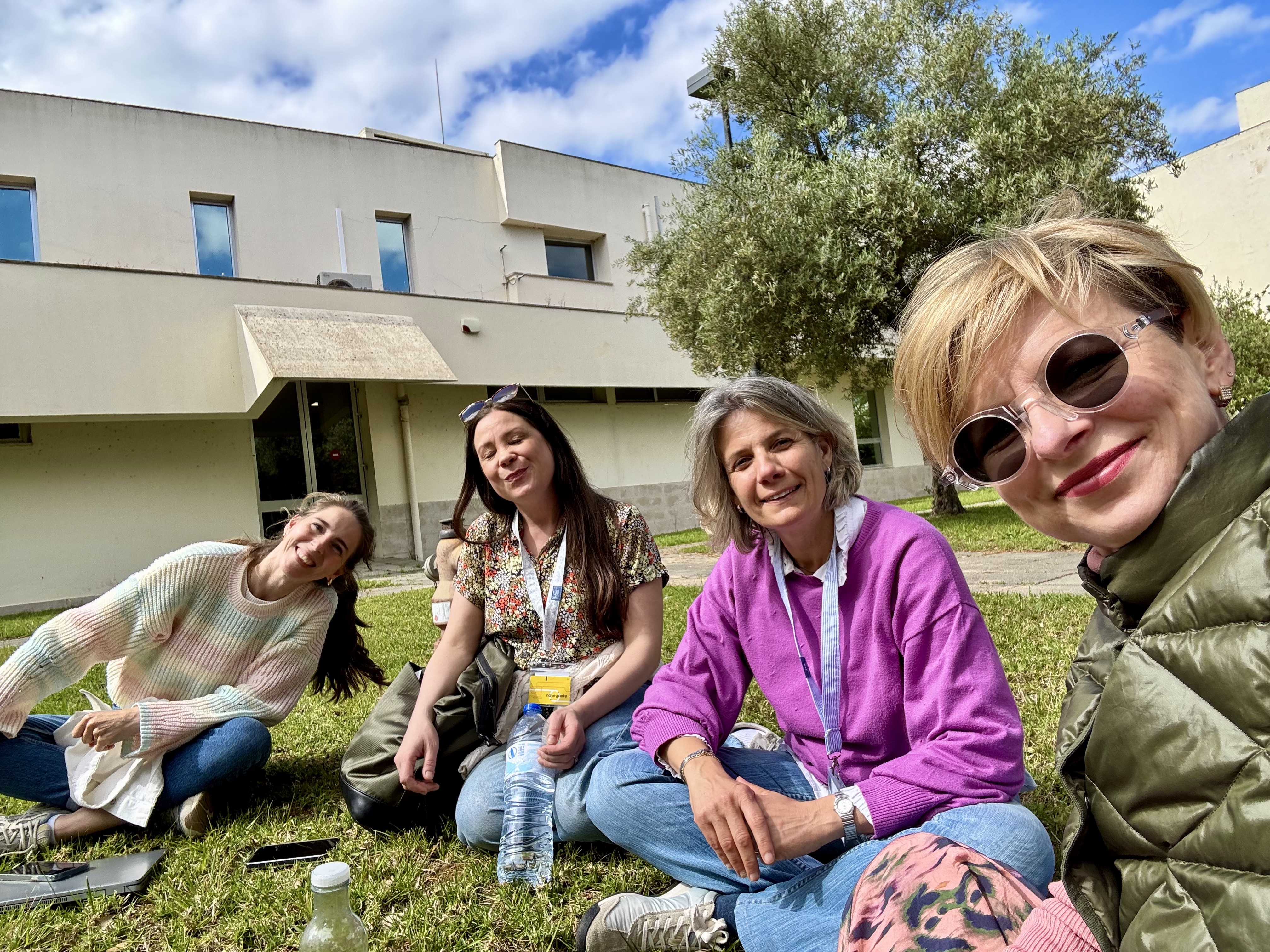 uczestniczki siedzą na trawie w parku