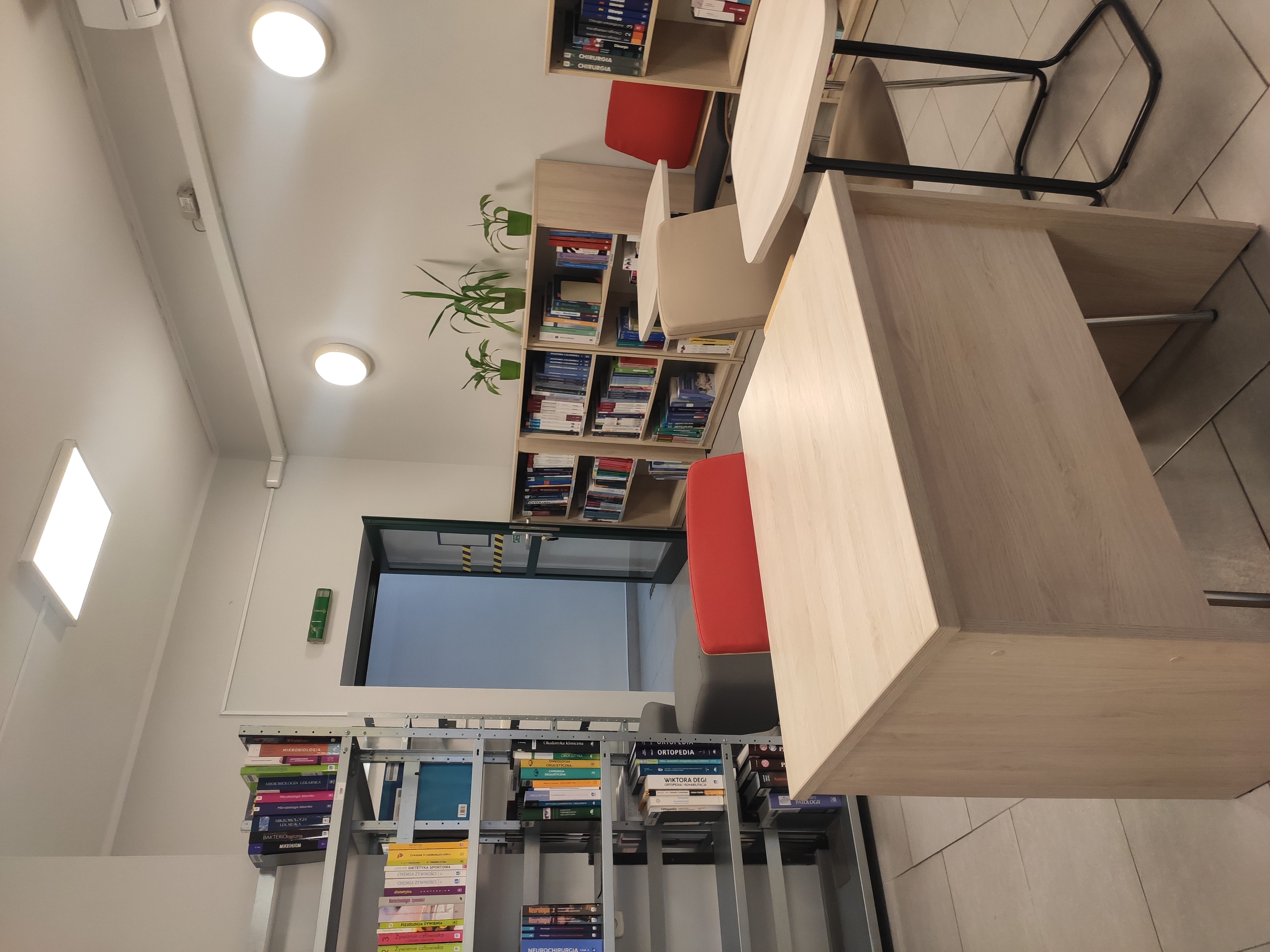 mała czytelnia, na zdjęciu widać półki z książkami, biurka i fotele dla studentów