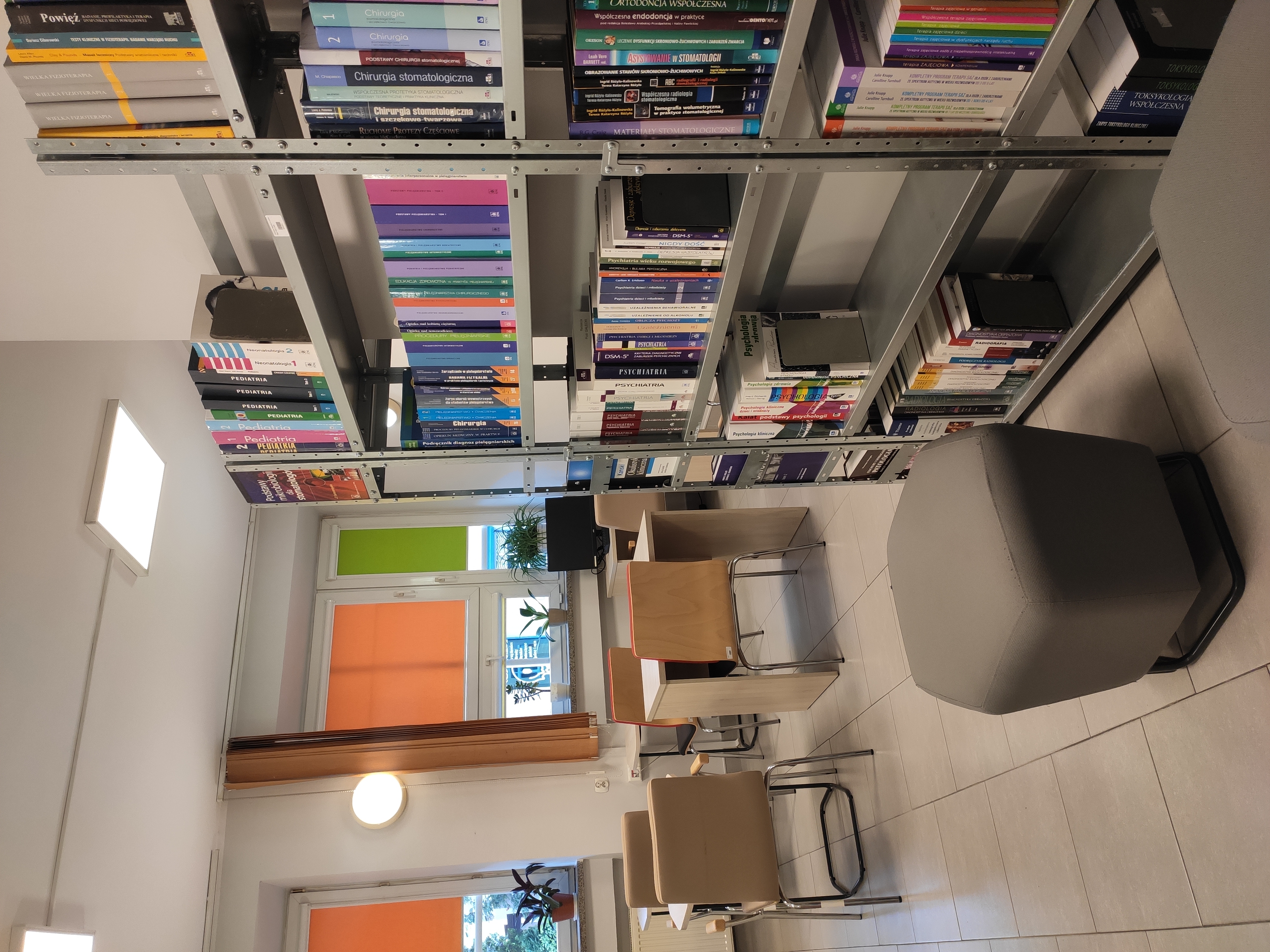 mała czytelnia, na zdjęciu widać półki z książkami, biurka i fotele dla studentów